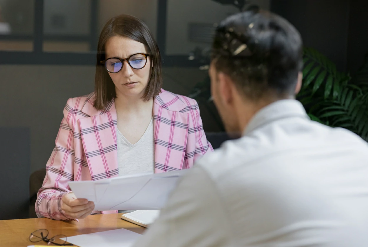 Femme consultant des dossiers devant un homme