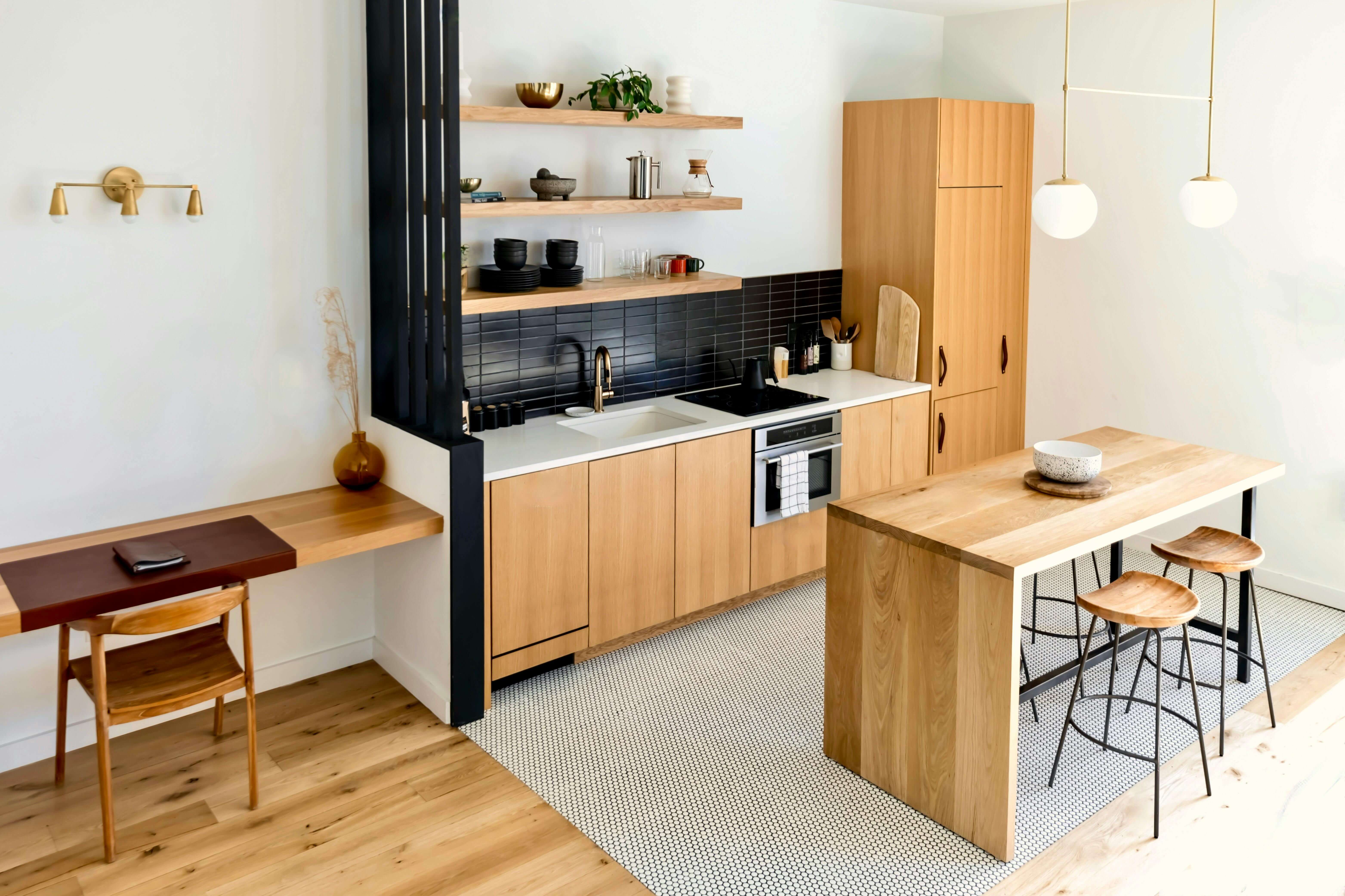 Un logement étudiant Bordeaux avec une kitchenette, une table à manger et des rangements modernes.